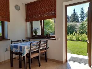 comedor con mesa, sillas y ventana en Lazdas en Saulkrasti