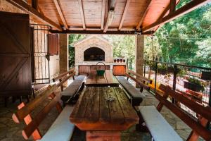 a long wooden table in a building with benches at Vacation Home Hercegovka in Čapljina