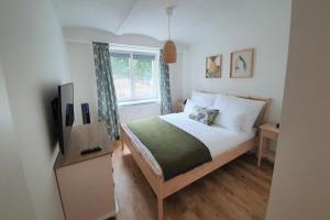 a bedroom with a bed and a television and a window at PB Ferienwohnungen - FeWo 1 - Stilvoll eingerichtetes Apartment im Herzen Senftenbergs in Senftenberg
