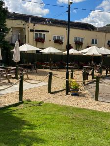 a group of tables with umbrellas in a courtyard at Greyhound Country Inn in Honiton