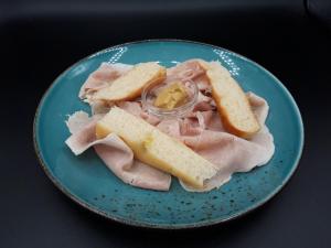 een blauwe plaat met ham en brood op een tafel bij Locanda Da Piero in Mirano