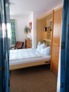 ein kleines Schlafzimmer mit einem Bett und einem Schrank in der Unterkunft FeWo Steckenbergblick/Gästecard in Unterammergau