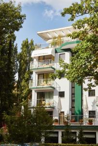 a white building with balconies and trees at Bernstein Hotel Villa Kastania in Berlin