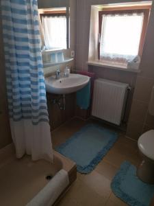 a small bathroom with a sink and a shower at FeWo Steckenbergblick/Gästecard in Unterammergau