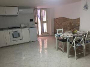a kitchen with a table and chairs and a kitchen with white appliances at La Dimora di Enea Via Indipendenza in Gaeta