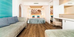 a living room with two beds and a couch at Insotel Tarida Beach Resort & SPA in Cala Tarida +49 photos