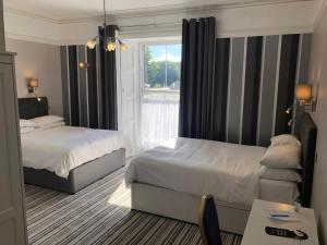 a hotel room with two beds and a window at Lowenac Hotel in Camborne