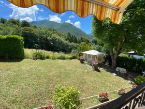 vista su un cortile con tenda e montagne di Mansarda Villa Simonetta a Esino Lario