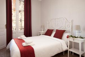 a bedroom with a white bed with red pillows at Whatching Sagrada Familia in Barcelona