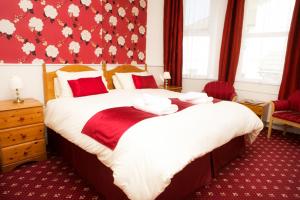 a bedroom with two beds and a red wall at Glendower in Torquay