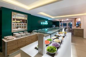 a buffet line with bowls of food in a restaurant at Sirocco Hotel in Zakynthos Town