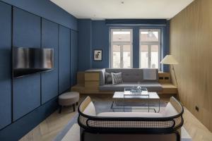 a blue living room with a couch and a table at Maximilian Hotel in Prague