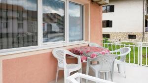 einen Balkon mit einem Tisch und Stühlen sowie einem Fenster in der Unterkunft Apartments Petkovic in Sokobanja