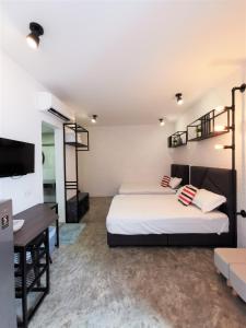 a bedroom with two beds and a desk and a tv at MWV Suite Room (MUAR) in Muar