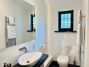 a white bathroom with a sink and a toilet at Millers House Boutique B&B in Emsworth