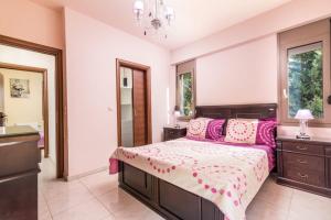 a bedroom with a large bed with pink pillows at Villa Olive Tree in Pitsidia