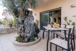 a table and chairs sitting next to a tree at Villa Olive Tree in Pitsidia
