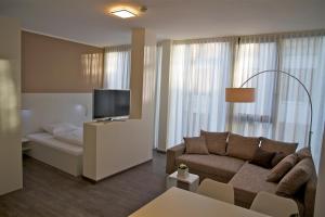 un soggiorno con divano e TV a schermo piatto di Boardinghouse Offenbach Service Apartments a Offenbach