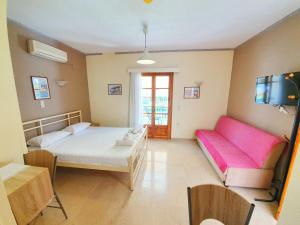 a room with a bed and a couch and a table at Alexaria Holidays Apartments in Lefkada