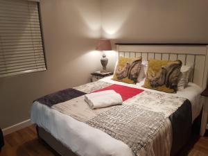 a bedroom with a large bed with a red blanket at Hart-se-Punt in Paternoster