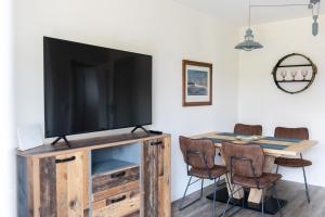 a living room with a television on a wooden entertainment center at Quartier Walzwerk in Püttlingen
