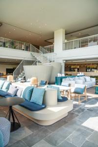 a lobby with blue and white chairs and tables at Empordà Golf Resort in Torroella de Montgrí