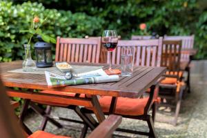 a wooden table with a glass of wine and a book at Hotel Carolinenhof in Berlin