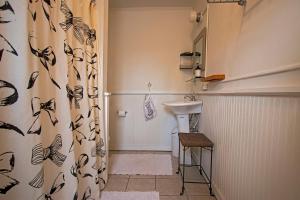 a bathroom with a sink and a shower curtain at The Woodbine Inn in Palenville