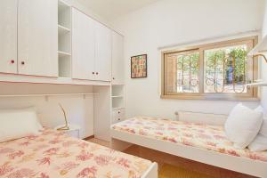 a bedroom with two beds and a window at Villa Cuckoo's Nest in Finale Ligure