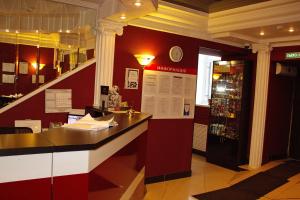 a bar in a restaurant with a red wall at Dukat Hotel on Ibragimova in Kazan