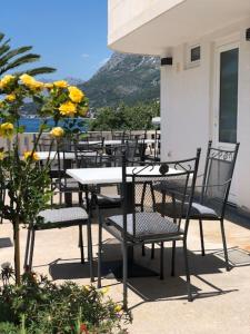 a table and chairs with yellow flowers on a patio at Villa Bosac in Gradac