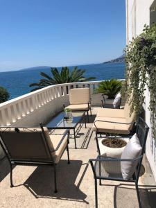 a patio with chairs and a table and the water at Villa Bosac in Gradac +11 photos
