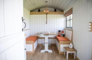 a small room with a table and benches in it at Perkins luxury shepherd huts in Nottingham