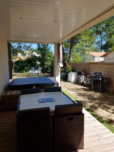 un patio con 2 tavoli da ping pong in un cortile posteriore di LES EMBRUNS a La Tranche-sur-Mer