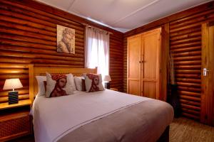 1 dormitorio con 1 cama grande y paredes de madera en Sunset Lodge, en St Lucia