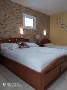a large bed in a bedroom with a brick wall at House Stella Tasos in Sarti