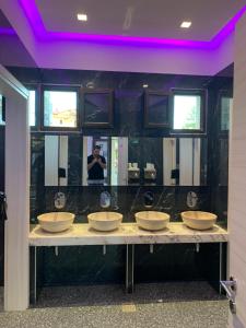 a man taking a picture of a bathroom with four sinks at Vergos Hotel in Vourvourou