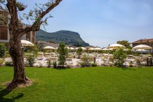 Blick auf ein Resort mit einer Liegewiese und Sonnenschirmen in der Unterkunft Residenza Olivo in Garda