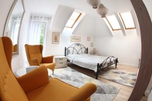 1 dormitorio con cama, silla y espejo en Bryza, en Łeba
