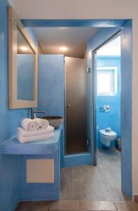 a blue bathroom with a sink and a toilet at Akti Naoussa Paros in Naousa