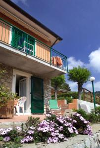 a house with a balcony with two chairs and flowers at Hotel Danila in Portoferraio