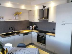 a kitchen with white cabinets and a sink and a table at Apartment Nana in Supetarska Draga