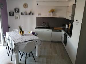 eine Küche mit einem Tisch und eine Küche mit einem Tisch und Stühlen in der Unterkunft Apartment Nana in Supetarska Draga