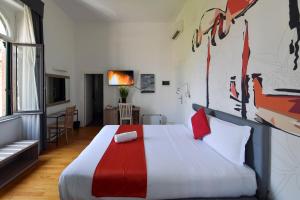 a bedroom with a large bed with red and white sheets at Suites Farnese Design in Rome