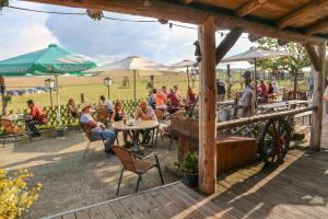 eine Gruppe von Personen, die an Tischen in einem Restaurant im Freien sitzen in der Unterkunft Rolling Home in Eppingen