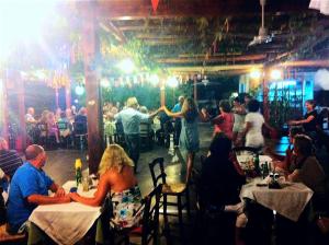 un groupe de personnes assises à des tables dans un restaurant dans l'établissement Anatoli Apartments, à Chersónissos