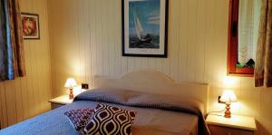 a bedroom with a bed with two lamps and a picture at Residence Villalsole in San Felice del Benaco