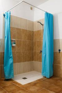 y baño con ducha con cortina azul. en ALBERGUE SAN JOSE DE LOS LLANOS en San Jose De Los Llanos
