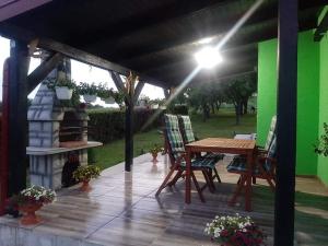um pátio com uma mesa e cadeiras e uma lareira em Ruralna kuća za odmor Viktorija em Čaglin