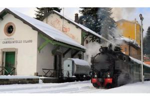 un train à vapeur qui descend dans une gare dans la neige dans l'établissement Camigliatello Mom&Son, à Camigliatello Silano